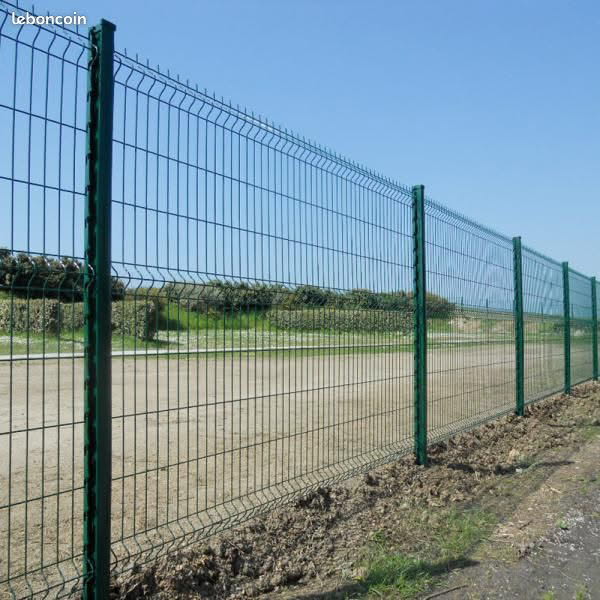 Clôture en panneau rigide grillage vert avec poteaux, devant un chemin de terre. leboncoin.
